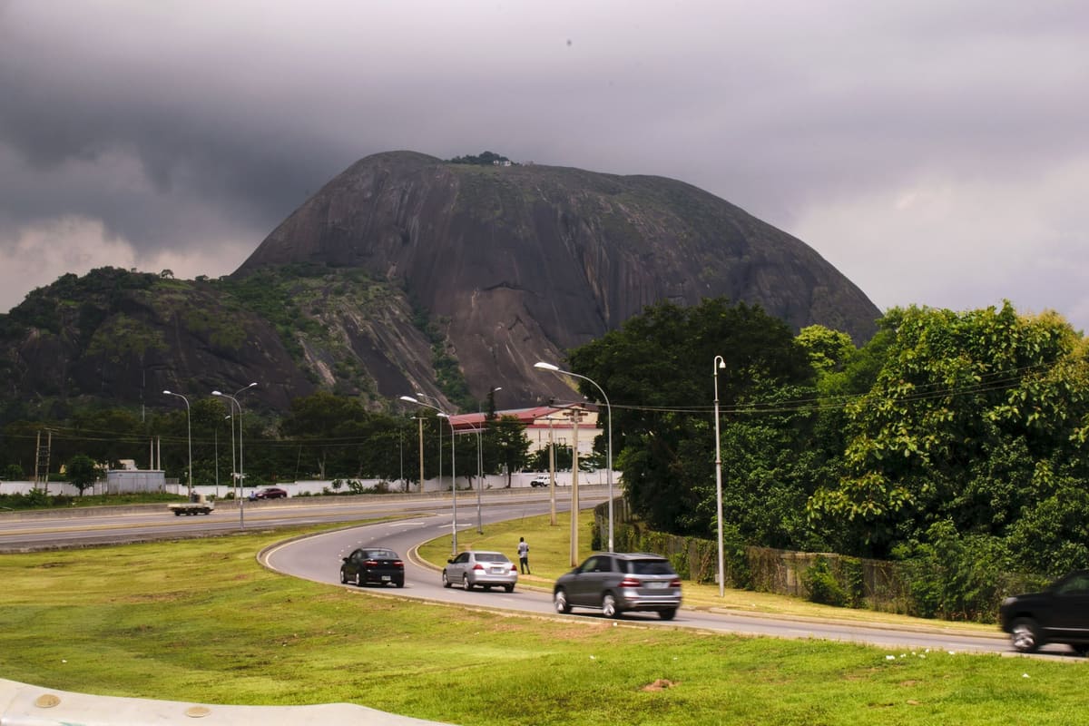 A road in Abuja beneath Aso Rock